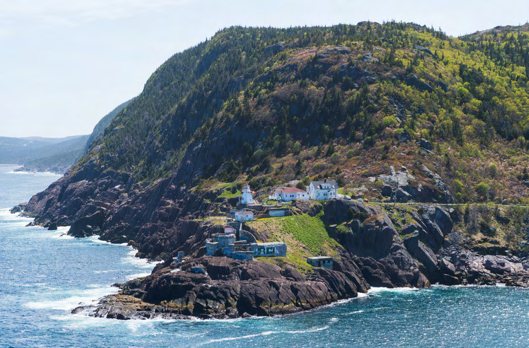 A fortified white building on a rocky headland above the sea, colour-graded.