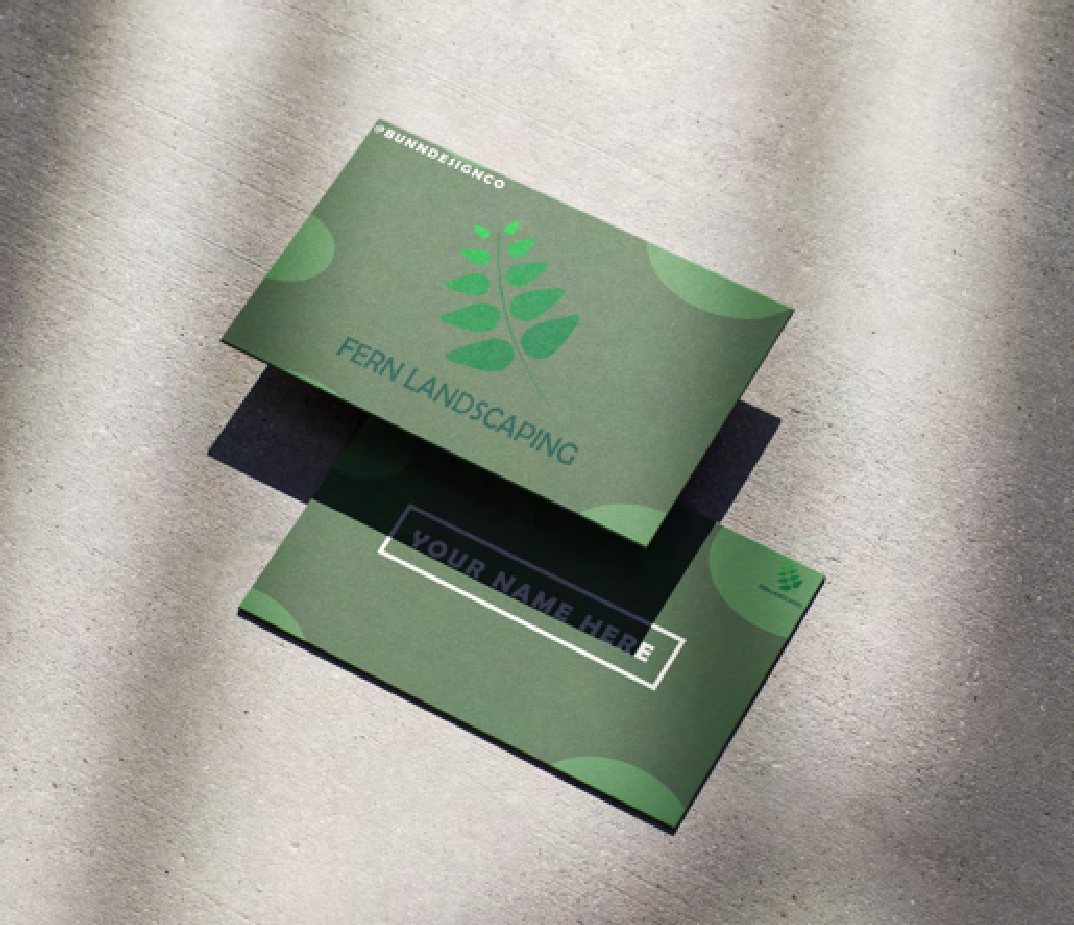 Two green Fern Landscaping business cards on textured fabric, one showing the frond mark.