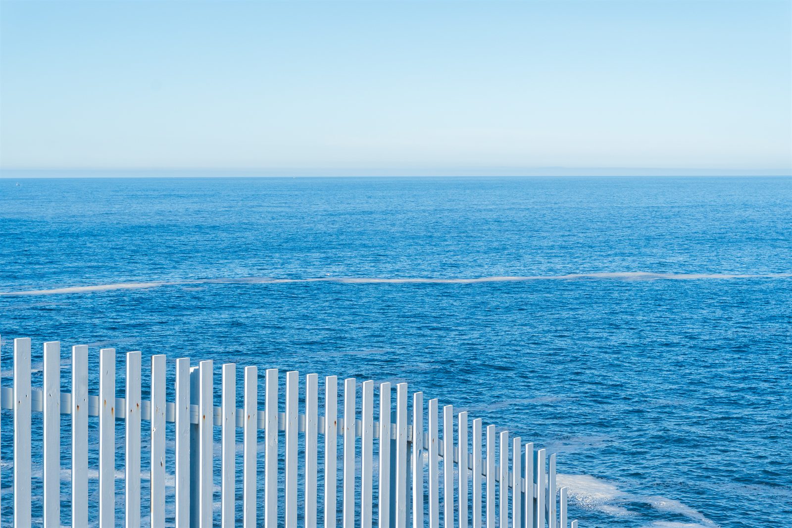A white picket fence overlooking the open Atlantic at Cape Spear.