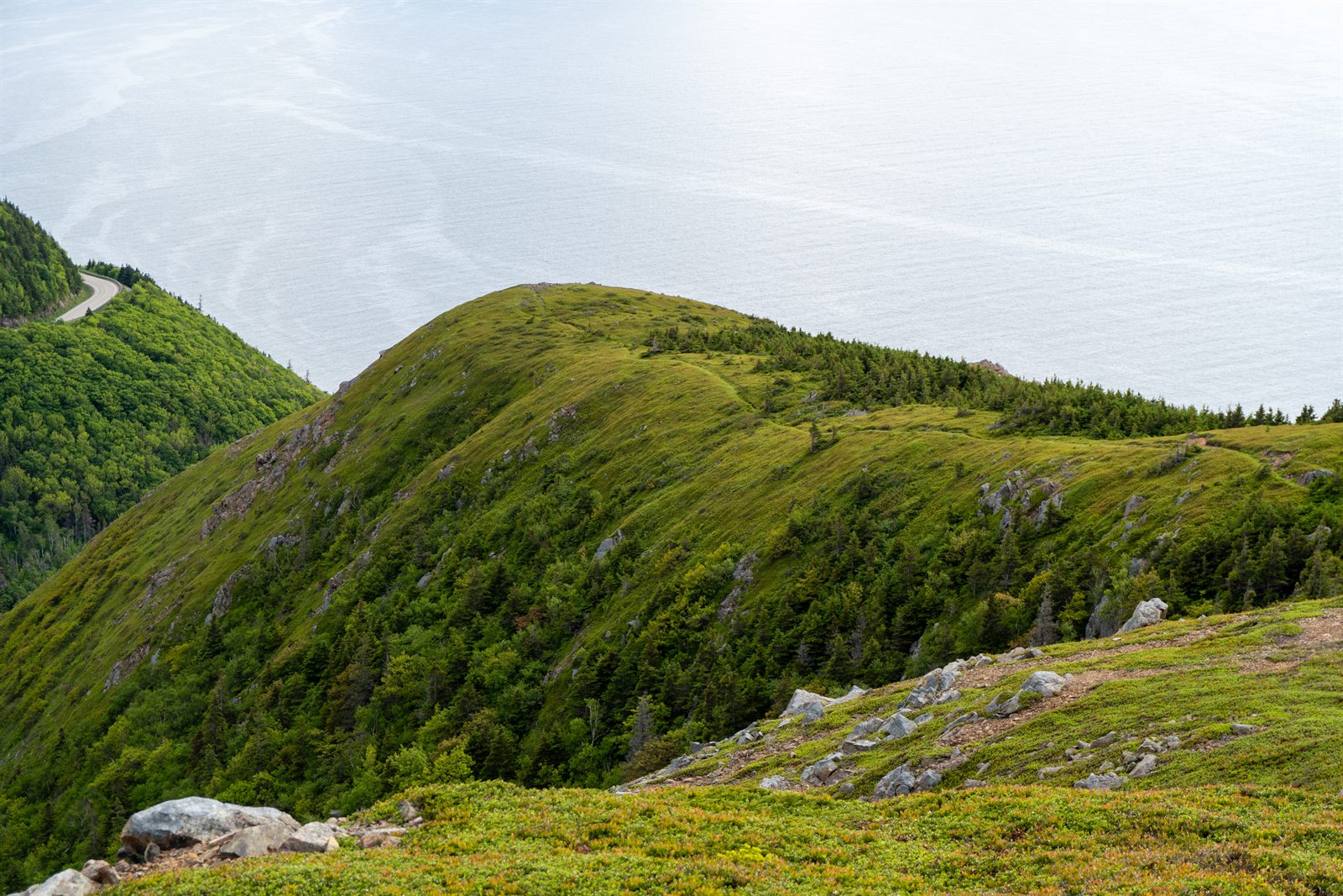 A green ridge above the coast road on the Cabot Trail.