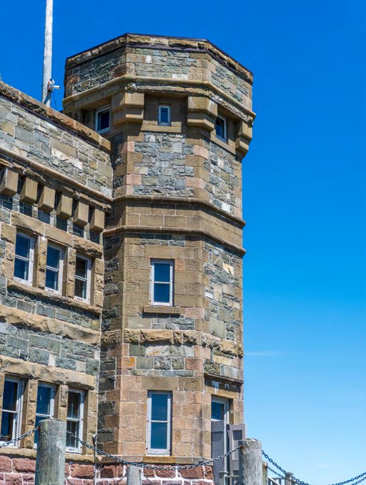 A stone tower with arched windows rising against a deep blue sky.